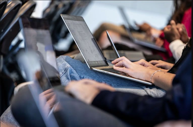 Estudantes universitários digitando em notebooks